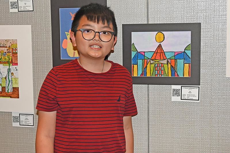 Holmsley Elementary School fourth grade student Alan Nguyen stands next to his artwork at the CFISD Spring Art Show.